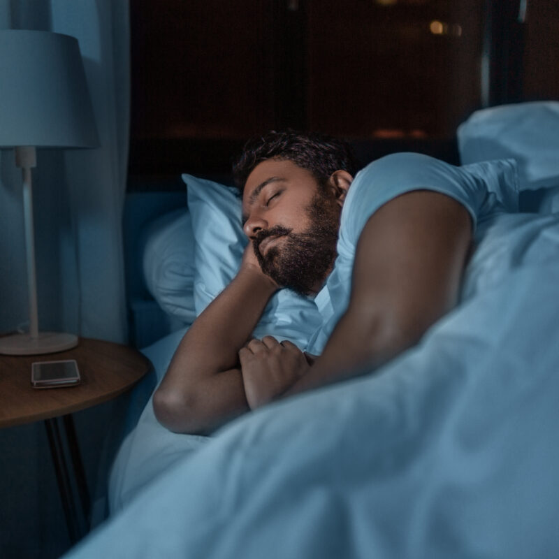 man sleeping in bed at home at night