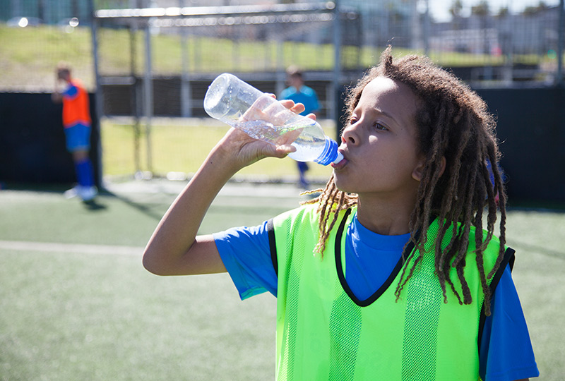 Boy drinking water during soccer practice
