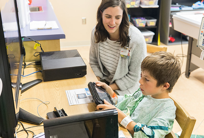 A Vanderbilt child life specialist plays a computer game with a patient