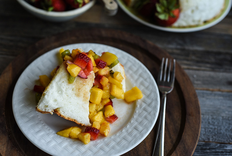 A slice of angel food cake with fruit salsa spooned over it.