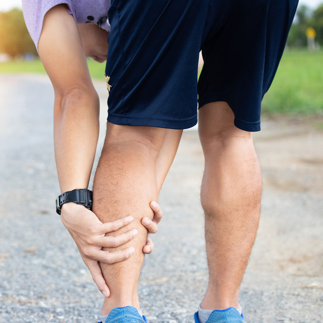 Runner massaging pain in leg. Consider PAD treatment.