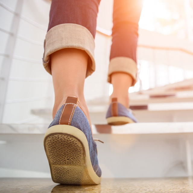 Image of woman walking and avoiding a sedentary lifestyle.