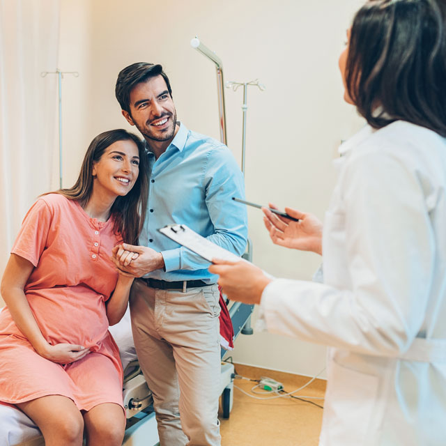 A pregnant couple speaking to provider on creating a birth plan.