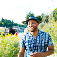 African American man stands near wildflowers