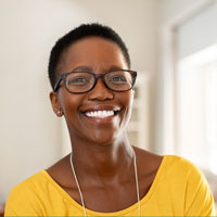 Smiling African American woman in glasses and bright yellow top