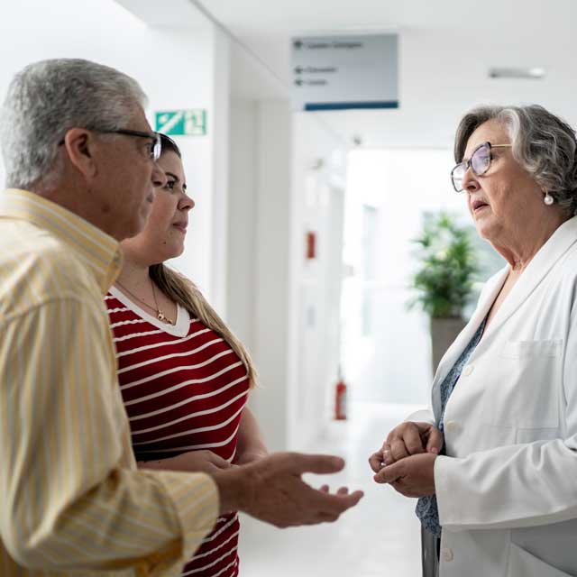 Man and woman asking doctor questions.