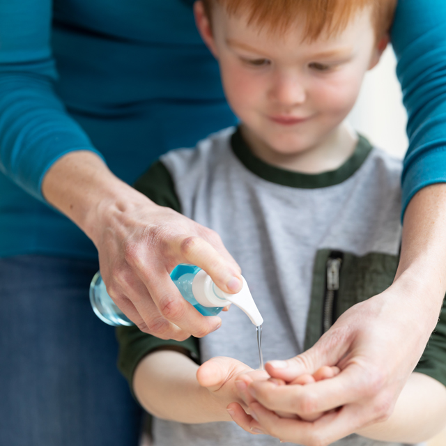 parent squirting hand sanitizer in young child's hand, hand sanitizer safety