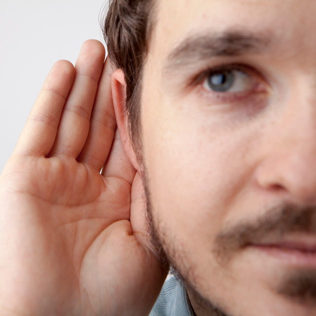Man with hand behind ear
