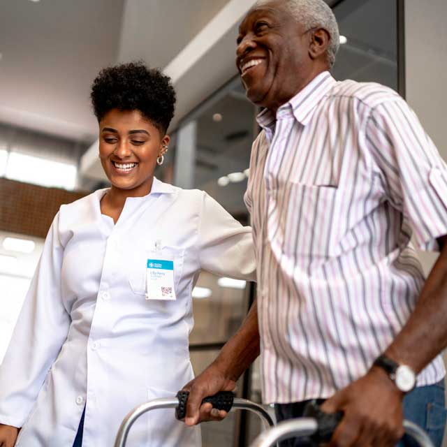 Doctor helping patient walk with a wheel chair