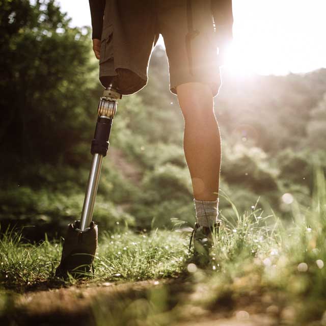 Male hiking in the woods in prosthetic leg