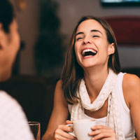 Young woman laughs with a friend.