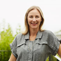 Middle aged white woman standing outdoors in a garden.