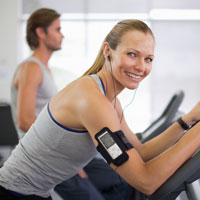 White woman rides an exercise bike.