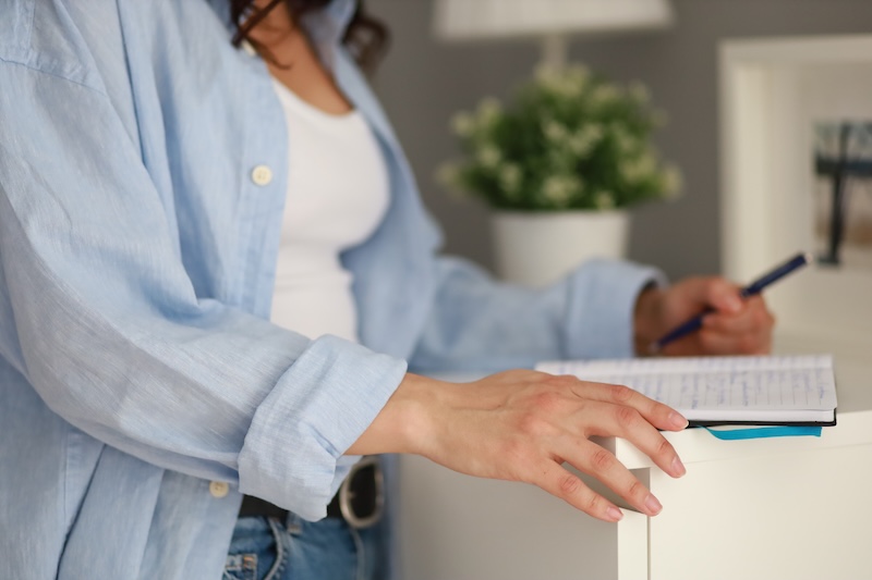 A woman writes in a notebook.