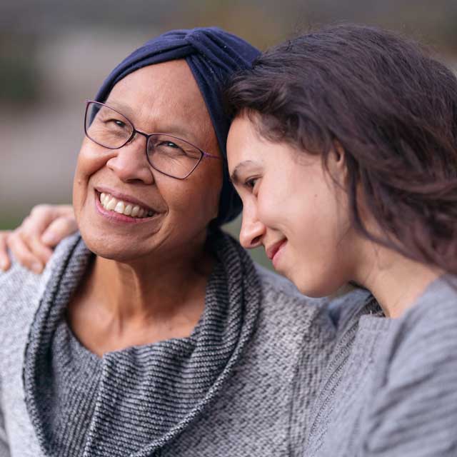 Woman embracing patient receiving endometrial cancer treatment