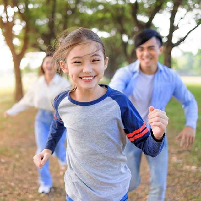 Kid running with parents behind
