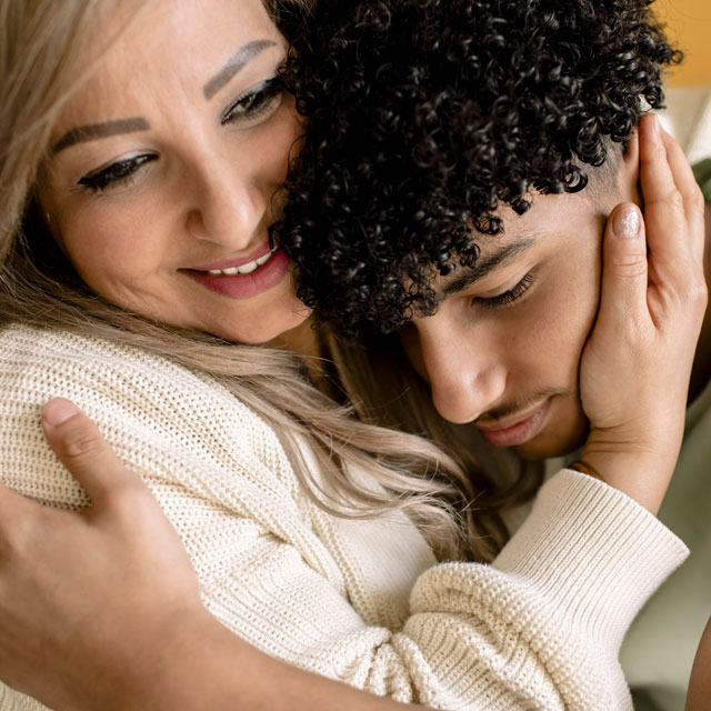 Closeup of a Latino woman embracing her teenaged son