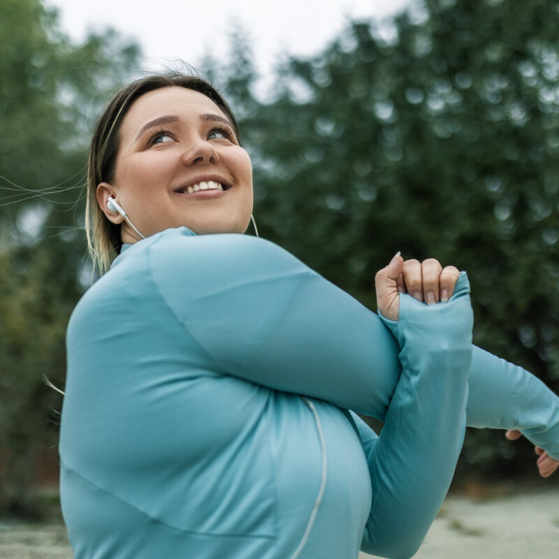 Young woman stretching by the river